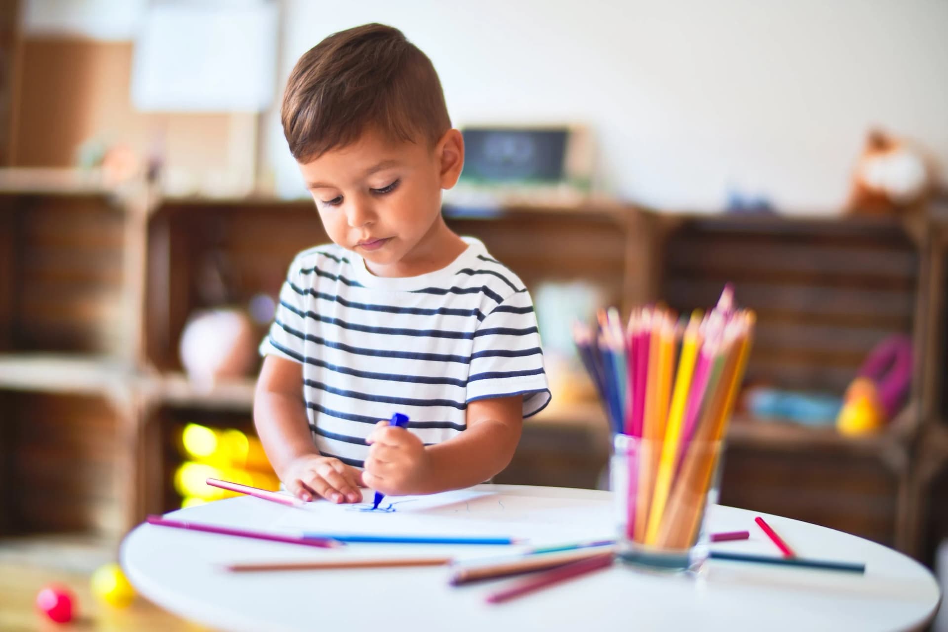 A child mark-making at a table